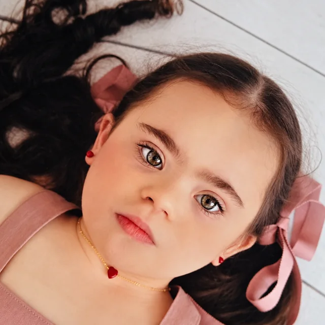 Bracha with pink hair bows and a heart necklace