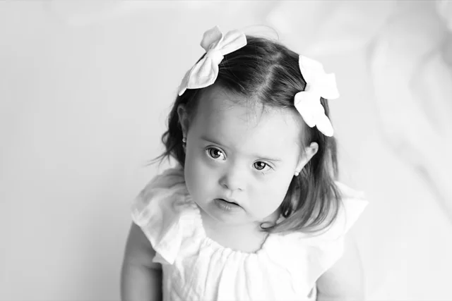 Chavy in a white dress and hair bows